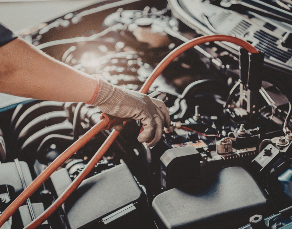 Mechanic applying jumper cables to a car battery